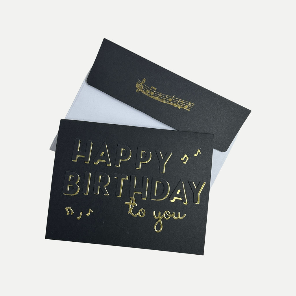 Handmade black and gold birthday card displayed with its coordinating decorated envelope.
