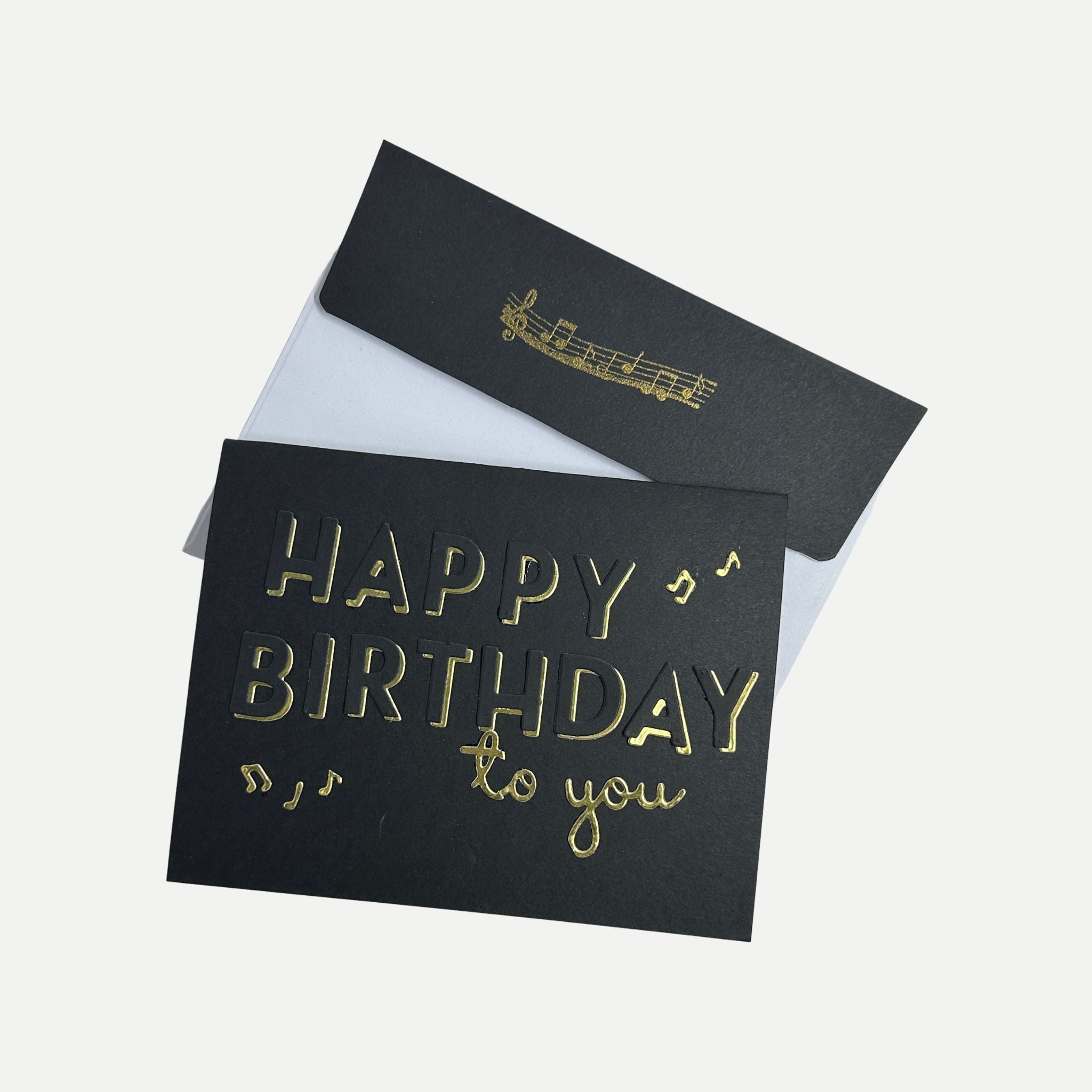 Handmade black and gold birthday card displayed with its coordinating decorated envelope.