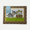 Handmade rustic birthday card featuring a smiling cow beside a sunflower fence with plaid background.