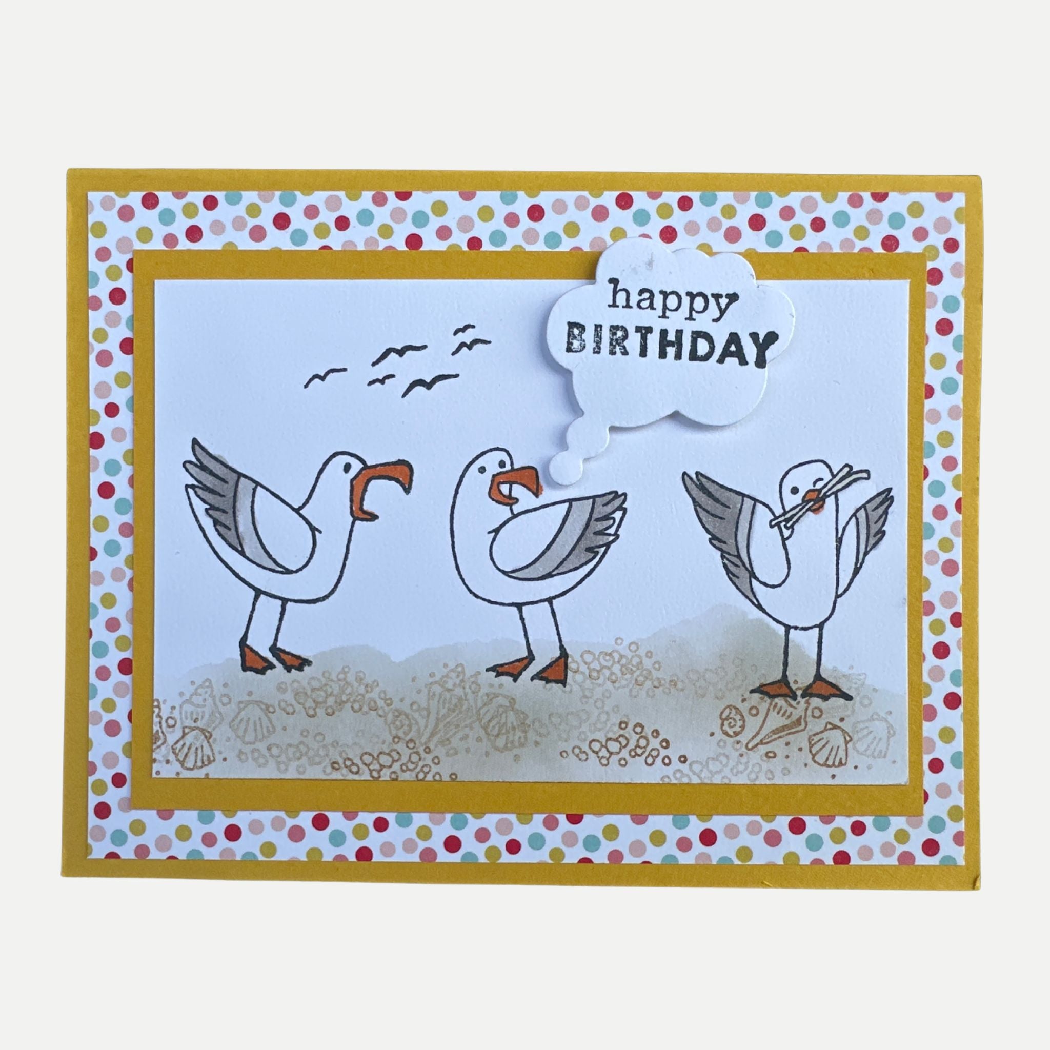 Handmade birthday card featuring three playful seagulls on a beach with a dimensional Happy Birthday speech bubble.