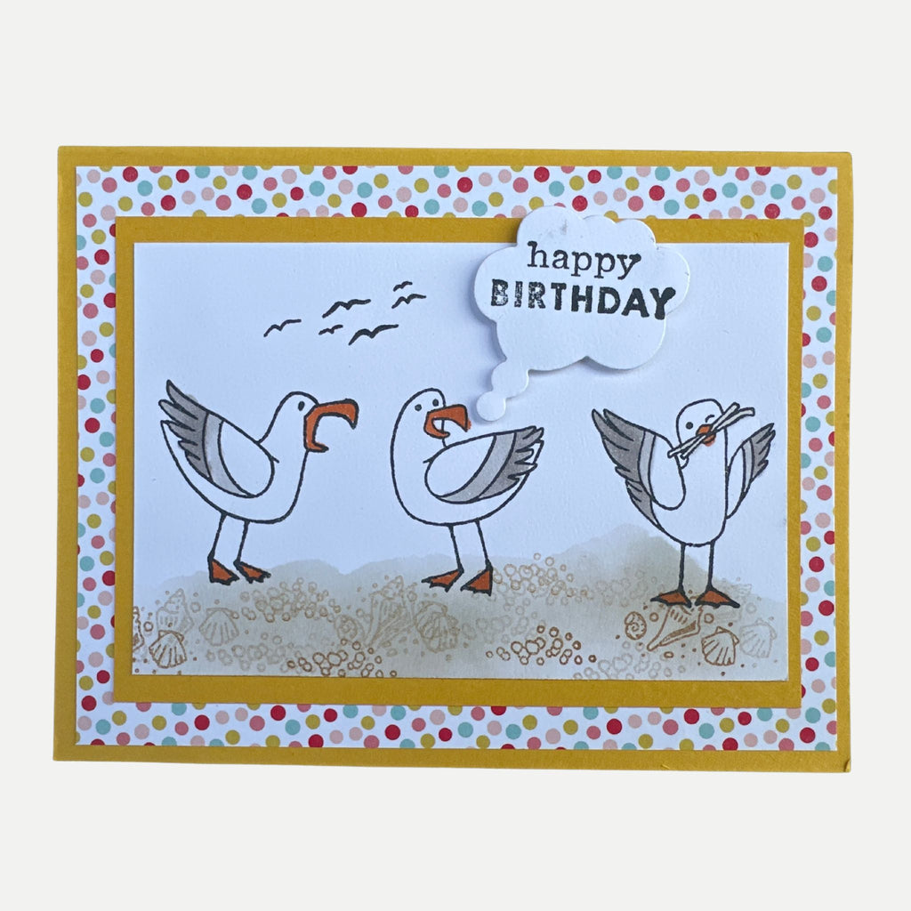 Handmade birthday card featuring three playful seagulls on a beach with a cheerful Happy Birthday greeting.