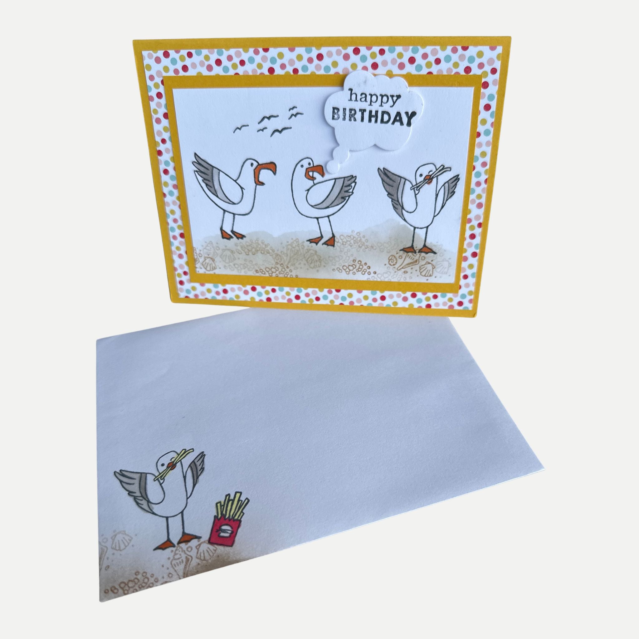 Funny handmade seagull birthday card displayed with its coordinating decorated envelope featuring a playful beach-themed design.
