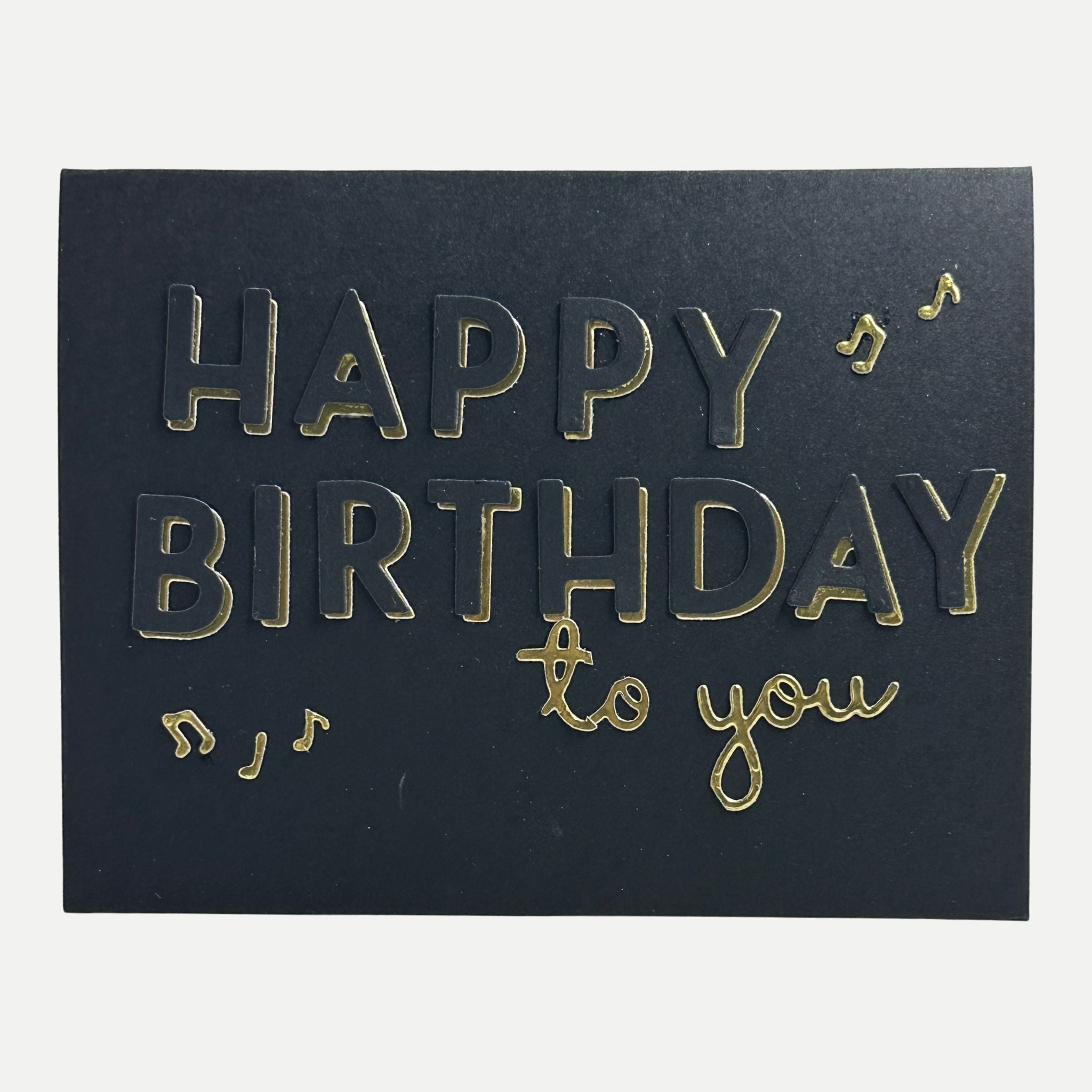 Elegant handmade black birthday card featuring gold foil "Happy Birthday to You" lettering with musical note accents.