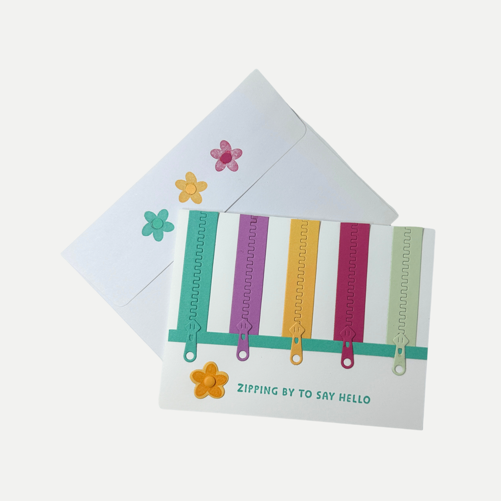 Handmade birthday card displayed with a coordinating envelope decorated with colorful zipper accents and stars.