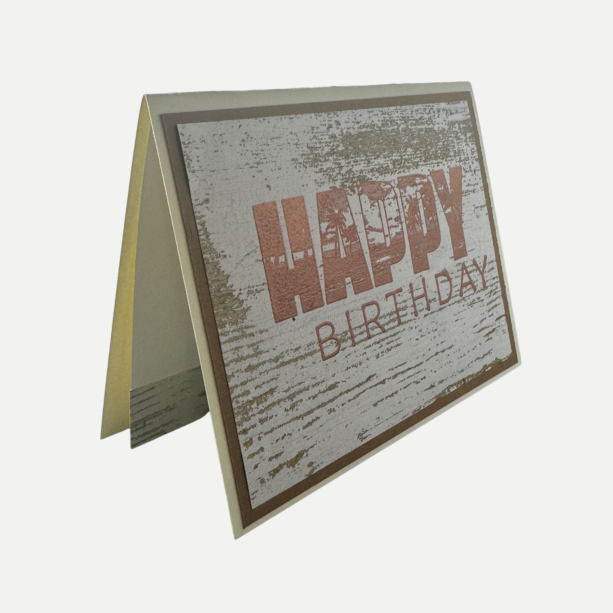 Angled view of handmade rustic birthday card showing copper foil details and premium cardstock.