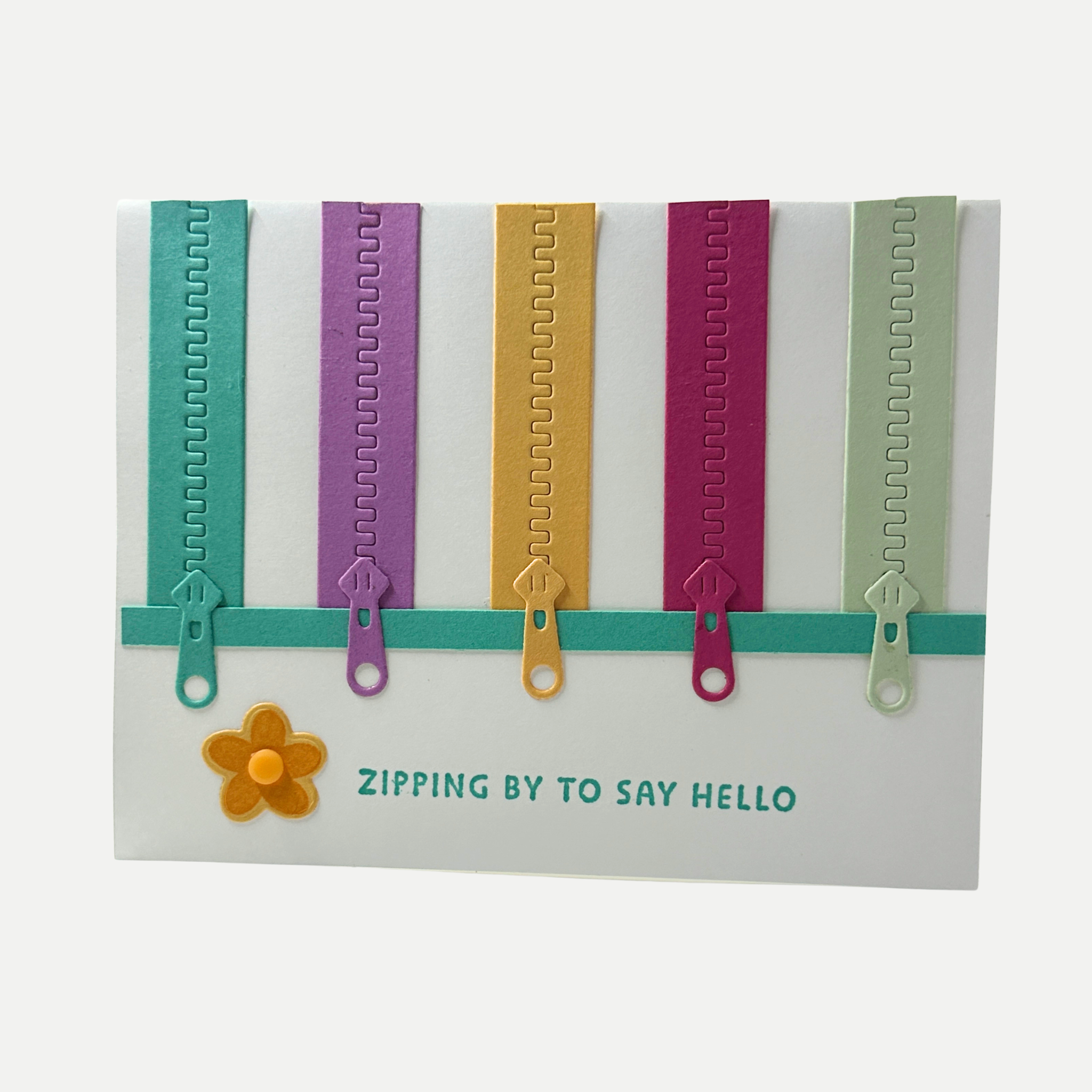 Handmade birthday card featuring colorful zipper embellishments with the greeting "Zipping by to Say Hello."