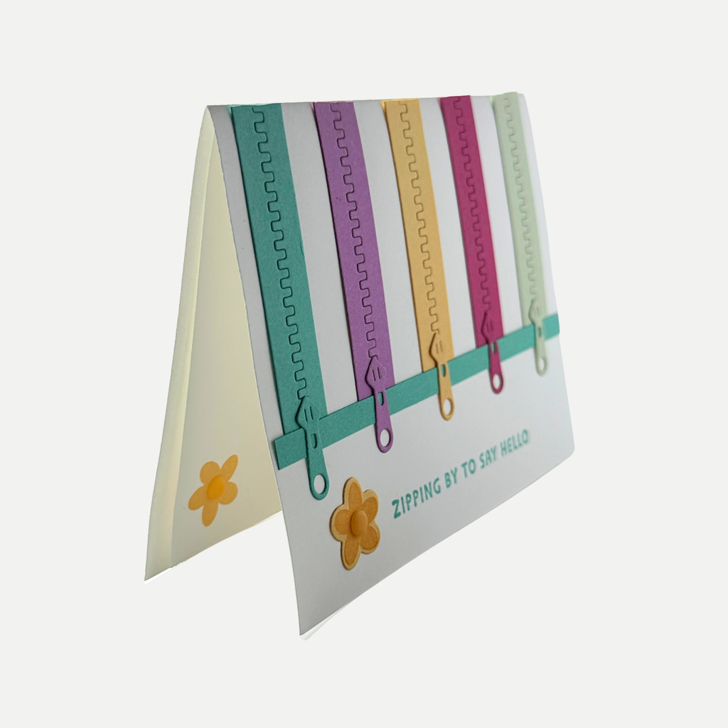 Side view of handmade zipper birthday card showing the dimensional zipper embellishments and layered design.